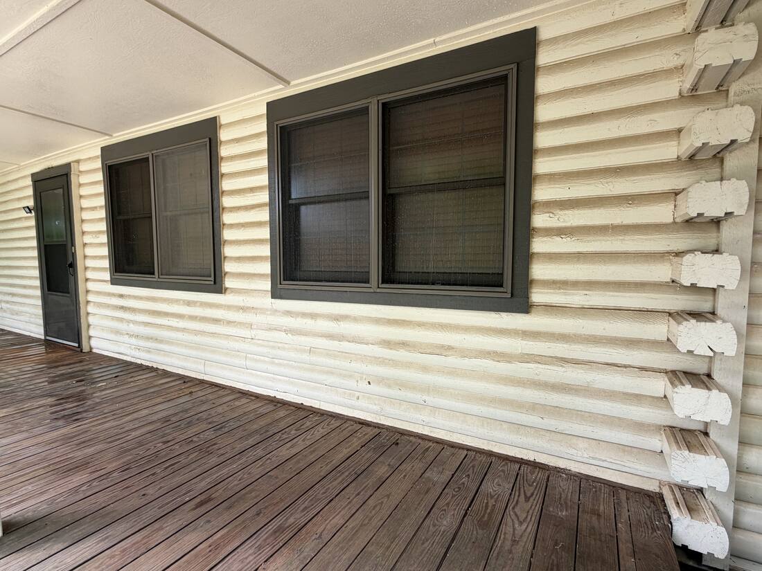 Log home siding before soft washing, grimy lower logs