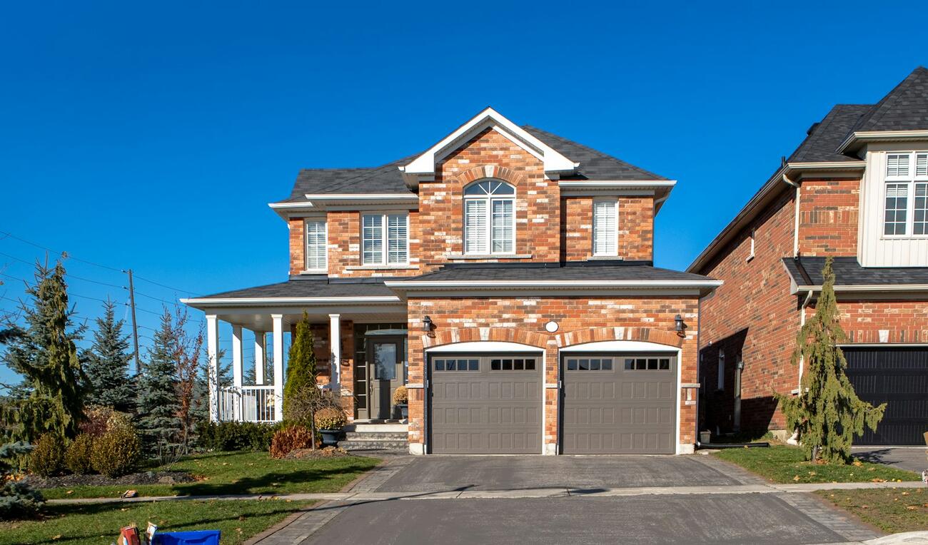 A clean two-story brick home with a freshly washed driveway